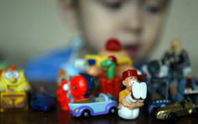 A child plays with small toys collected from the famous Kinder suprise-filled chocolate eggs by Italian confectioner Ferrero in Berlin 15 April 2004.
