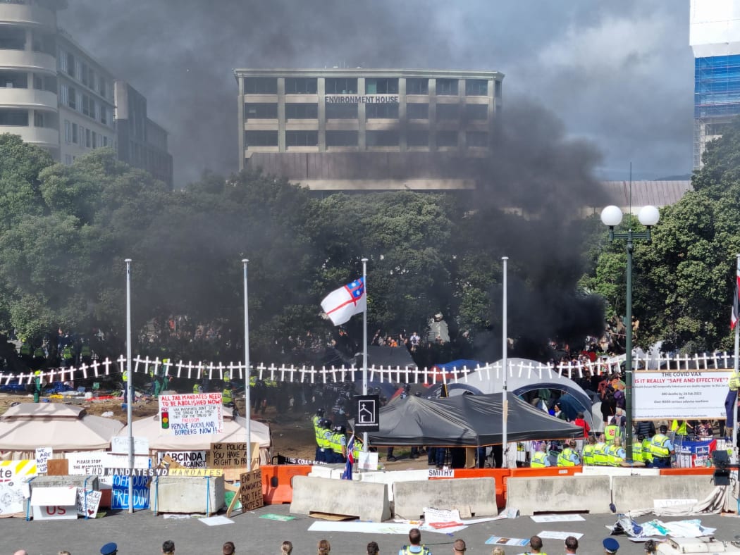 Something is set on fire but police come in with fire extinguishers to put it out.