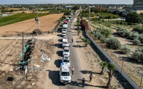 This aerial view shows humanitarian aid trucks arriving from Egypt after having crossed through the Rafah border crossing arriving at a storage facility in Khan Yunis in the southern Gaza Strip on October 21, 2023. The first aid trucks arrived in war-torn Gaza from Egypt on October 21, bringing urgent humanitarian relief to the Hamas-controlled Palestinian enclave suffering what the UN chief labelled a "godawful nightmare". Israel has vowed to destroy Hamas after the Islamist militant group carried out the deadliest attack in the country's history on October 7. (Photo by Belal Al SABBAGH / AFP)