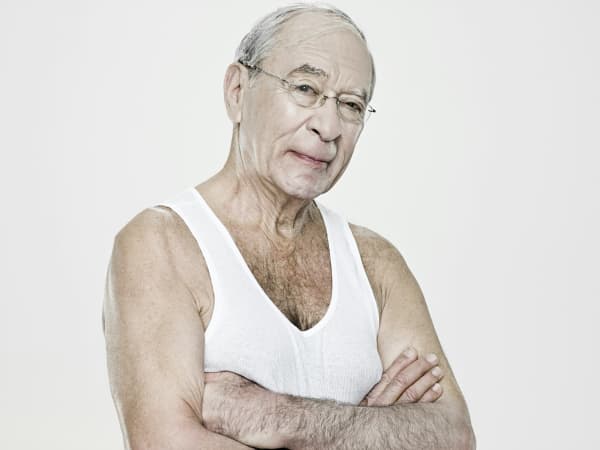 A senior man in a white singlet.