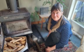 Rebecca James with the old woodburner that has been assessed as unsafe to use.