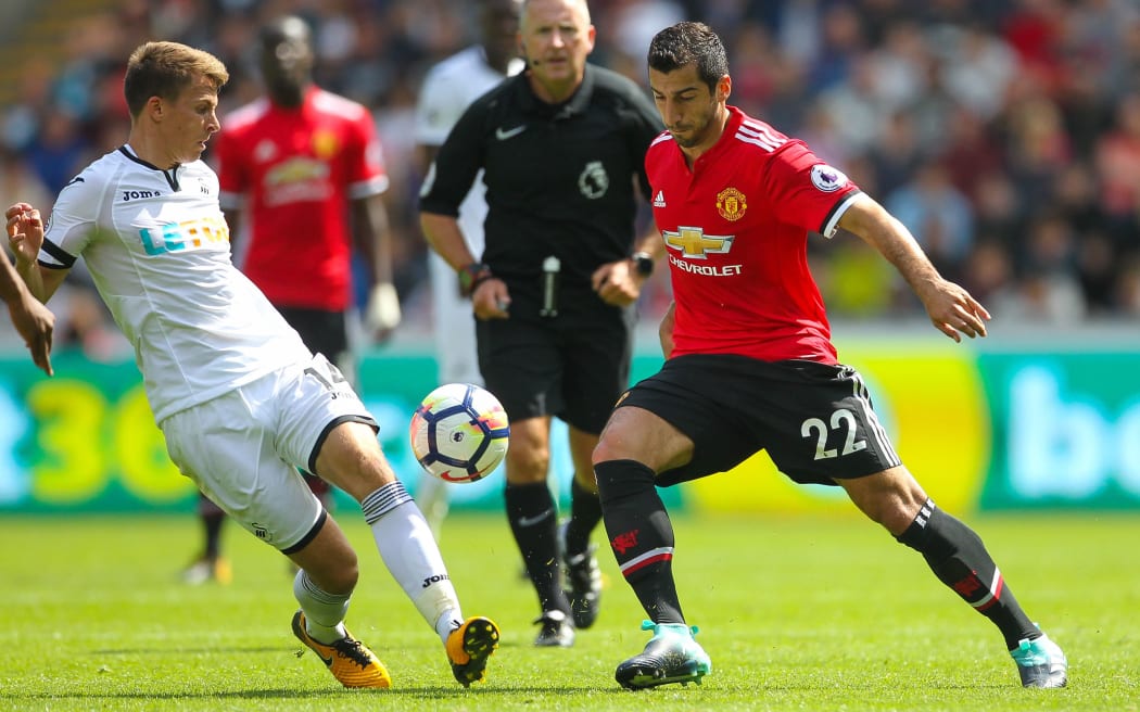 Henrikh Mkhitaryan (R) of Manchester United and Tom Carroll of Swansea City contest possession.