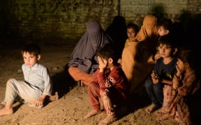 A family gather after evacuating their home in Muridke, about 30kms from Lahore on May 7, 2025. India fired missiles at Pakistani territory early on May 7, killing at least three people, according to Pakistan, which said it had begun retaliating in a major escalation of tensions between the nuclear-armed rivals. (Photo by Murtaz Ali / AFP)