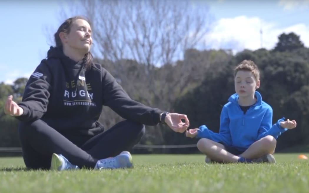 Erin Rayner (therapist) and Euan Lord soaking up the sun and fun of Sense Rugby. Waikanae Park. 2020.