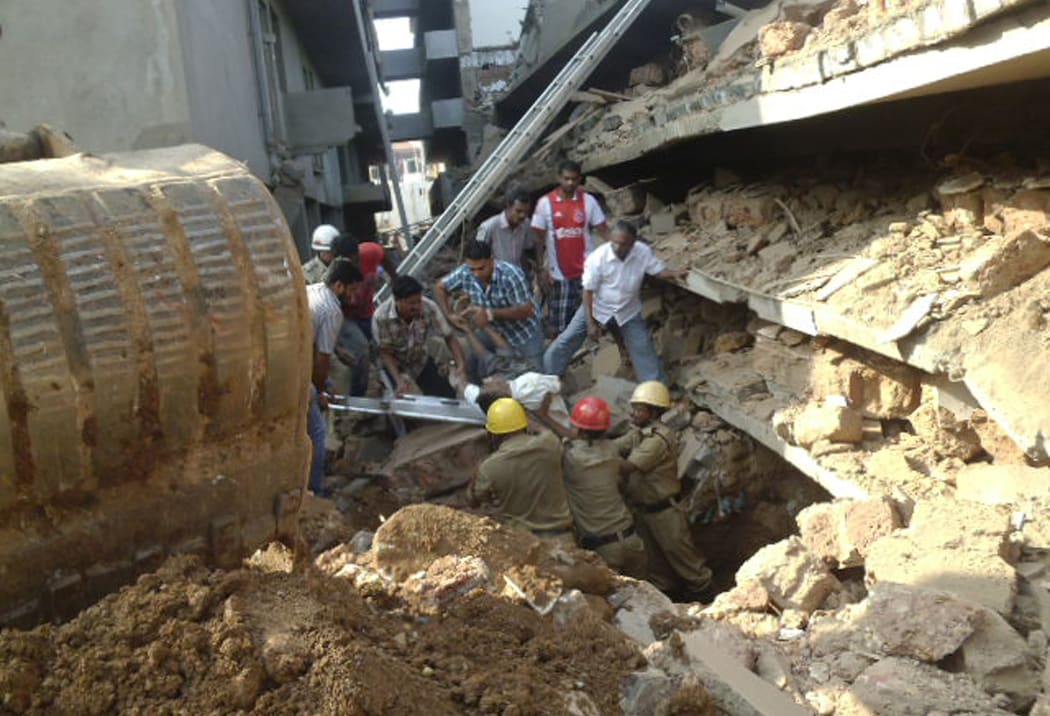 Rescue workers pull a person from the rubble in Canacona.