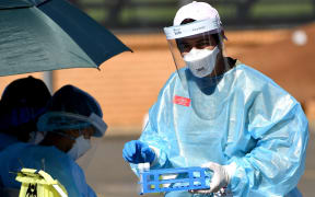 A health worker collects swab samples at a Covid-19 coronavirus drive through testing site in the Smithfield suburb of Sydney on August 12, 2021.