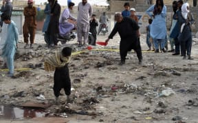 People gather at the site of a suicide bomb attack that targeted a procession marking the birthday of Islam's Prophet Mohammed in Mastung district on September 29, 2023. More than 50 people were killed and dozens more wounded in Pakistan's Balochistan province on September 29 by a suicide bomber targeting a procession marking the birthday of Islam's Prophet Mohammed, officials said. (Photo by Banaras KHAN / AFP)