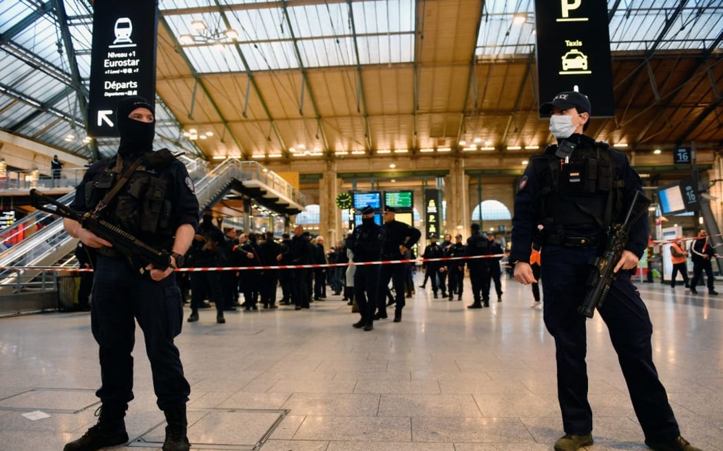 French police stand guard in a hall of Paris' Gare du Nord train station, after several people were lightly wounded by a man wielding a knife on January 11, 2023. - The man was arrested by police at the station, which serves as a hub for trains to London and northern Europe, after they opened fire and wounded him, said a police source, who asked not to be named. (Photo by JULIEN DE ROSA / AFP)