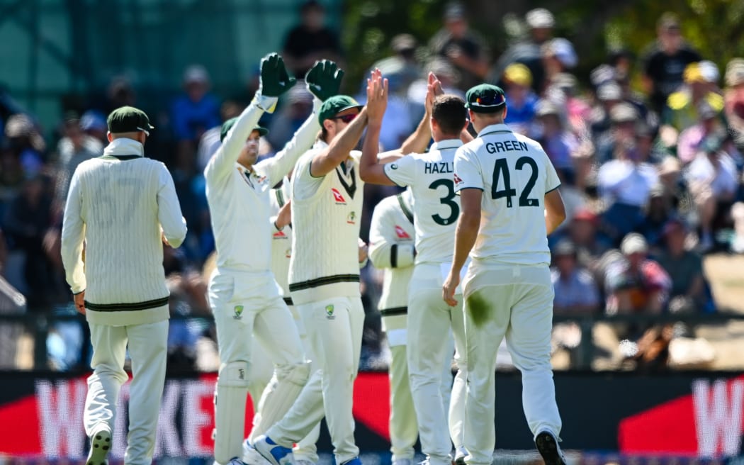 Josh Hazelwood and his Australian teammates celebrate the dismissal of Darryl Mitchell.