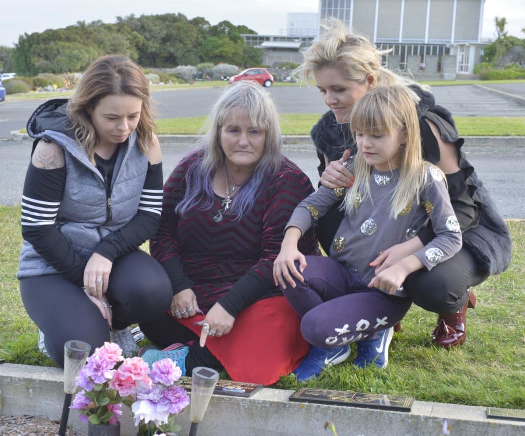 Kimberley Gray (left), her mother Donna Hayes Cox, sister Kylie Hayes, and Ms Hayes’ daughter Jeila Morrison, 8, look at the headstone belonging to Doug and Emma Hayes.