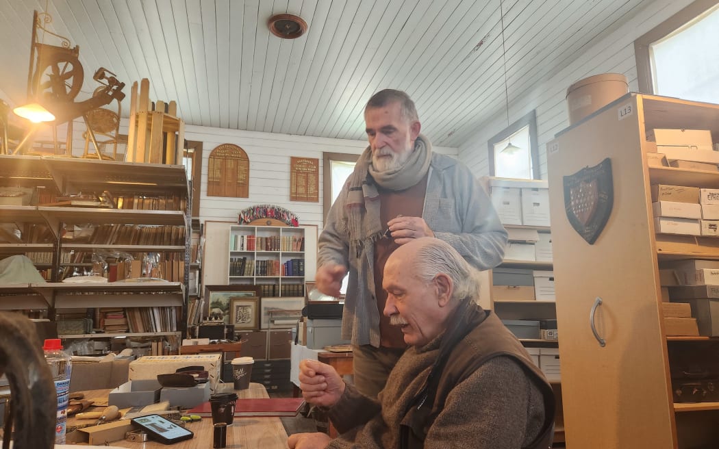 A view of the museum workroom with Ian Day seated and Bruce Laurence standing