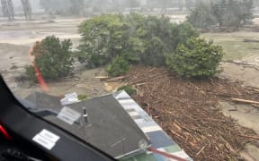 An NH90 helicopter and crew recover people from the rooftops of their homes in Esk Valley, Napier.