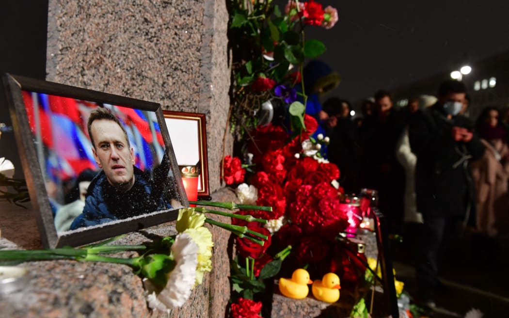 Ludzie zbierają się pod prowizorycznym pomnikiem zmarłego przywódcy rosyjskiej opozycji Aleksieja Nawalnego, zorganizowanym pod Pomnikiem Ofiar Represji Politycznych w Sankt Petersburgu 16 lutego 2024 r., po śmierci Nawalnego w swoim arktycznym więzieniu.  (Zdjęcie: Olga Maltseva/AFP)