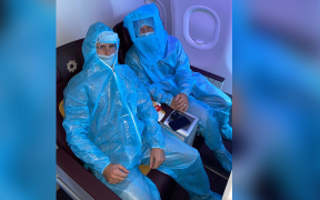 Kane Williamson and David Warner in full PPE on a flight to Delhi for India Premier League.