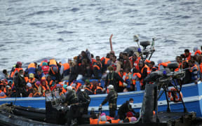 Migrants sit in a boat during a rescue operation off the coast of Sicily in May.