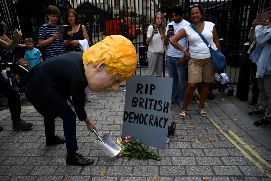 A man wearing a mask of Boris Johnson protests outside Downing Street over Parliament's suspension.