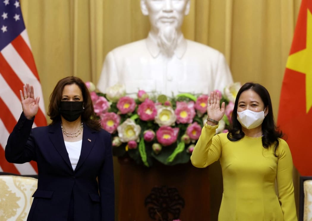 US Vice President Kamala Harris (L) waves beside Vietnam's Vice President Vo Thi Anh Xuan in the Gold room of the Presidential Palace in Hanoi on August 25, 2021.