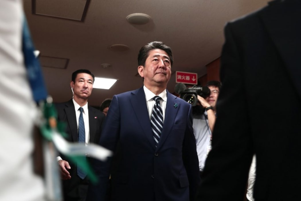 Japan's Prime Minister and ruling Liberal Democratic Party leader Shinzo Abe (C) arrives at the party headquarters.
