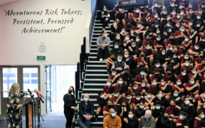 School students watch on as Associate Education Minister Jan Tinetti announces a plan to improve declining school attendance