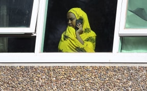 A resident looks from a window at one of nine public housing estates locked down due a spike in COVID-19 coronavirus numbers in Melbourne on July 6, 2020.