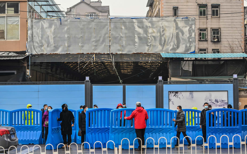 Workers place barriers outside the closed Huanan Seafood wholesale market during a visit by members of the World Health Organization (WHO) team, investigating the origins of the Covid-19 coronavirus, in Wuhan, China's central Hubei province on January 31, 2021.