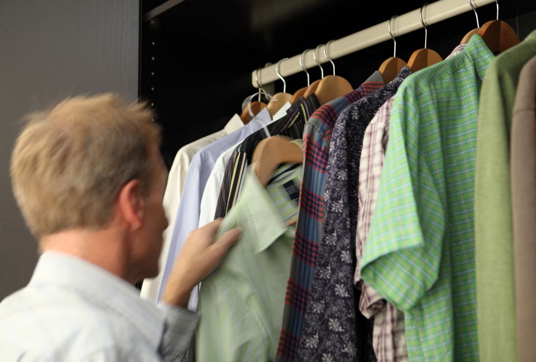 Man taking shirt from wardrobe (Photo by Simon Battensby / Image Source / Image Source via AFP)