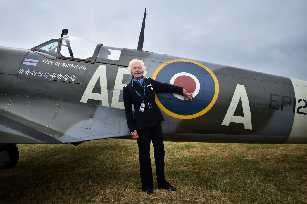 Battle of Britain veteran, pilot First Officer Mary Ellis, poses with a Spitfire aircraft.