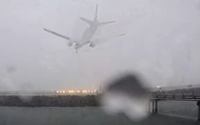 The Air New Zealand flight from Melbourne landing amid heavy rain and low visibility.