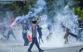 DENVER, CO - MAY 29: Protesters run from tear gas fired by police during a protest on May 29, 2020 in Denver, Colorado. This was the second day of protests in Denver