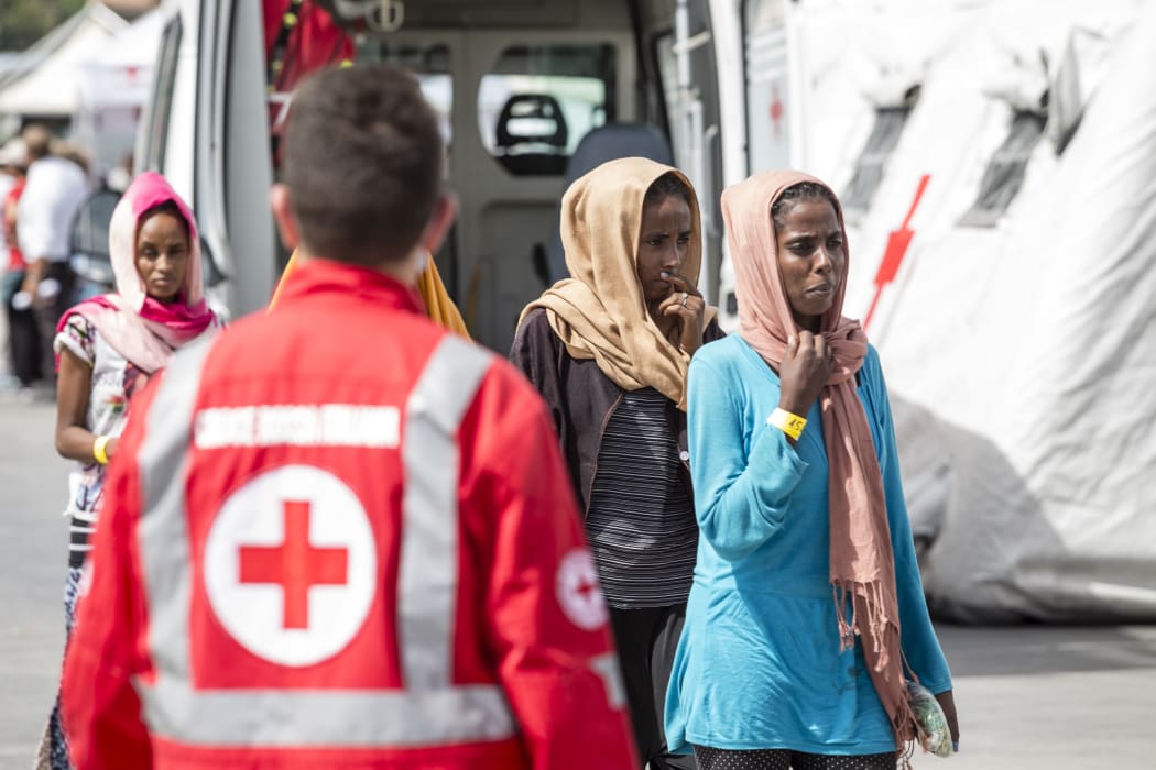Women rescued off the coast of Libya wait to be processed by authorities after arriving at the port of Palermo, Sicily on 24 August.