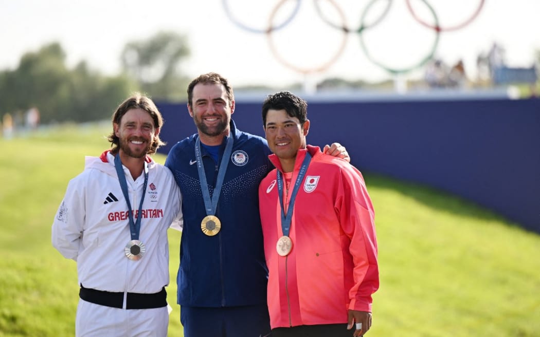 (L-R) Thomas Fleetwood of Great Britain, Scottie Scheffler of United States and Hideki Matsuyama of Japan celebrate during an award ceremony of the men's golf event of the Paris Olympics at Le Golf National in Saint-Quentin-en-Yvelines, France on August 4, 2024. U.S. Scottie Scheffler won the event to claim gold medal, Thomas Fleetwood placed 2nd to claim silver medal, and Hideki Matsuyama placed 3rd to claim bronze medal.( The Yomiuri Shimbun ) (Photo by Miho Ikeya / Yomiuri / The Yomiuri Shimbun via AFP)