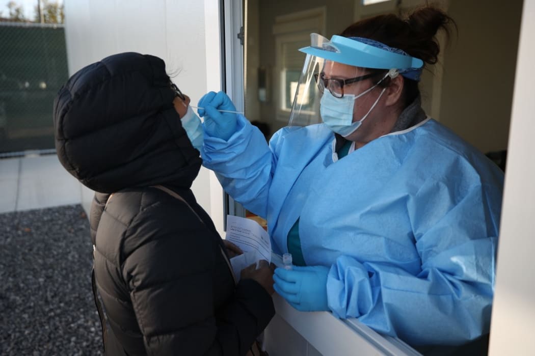 NEW YORK, USA - NOVEMBER 18: A woman is getting her coronavirus test as people line up for free COVID-19 test ahead of Thanksgiving in Queens of New York City, United States on November 18, 2020.