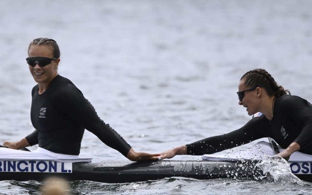 New Zealand's gold medallists Lisa Carrington and Alicia Hoskin celebrate their victory in the women's kayak double 500m final of the canoe sprint competition at Vaires-sur-Marne Nautical Stadium in Vaires-sur-Marne during the Paris 2024 Olympic Games on August 9, 2024. (Photo by Olivier MORIN / AFP)