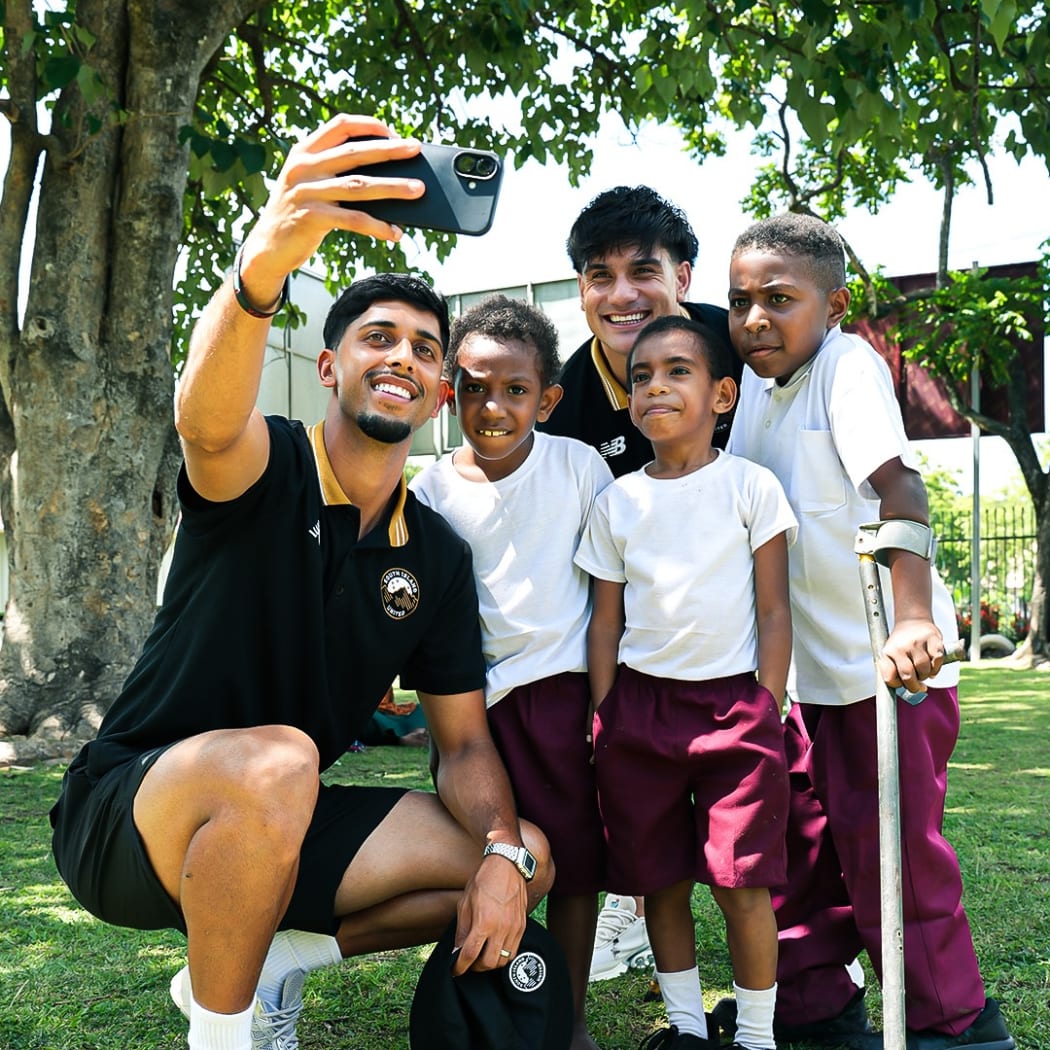 Cheshire Homes Disability Centre students with a South Island United player during the team's community visit on Thursday.