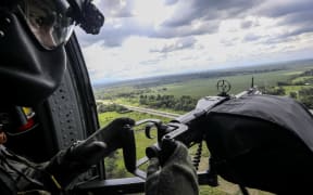 A Colombian Air Force soldier is pictured as he holds an alert position onboard a blackhawk helicopter overflying the Gulf of Uraba.