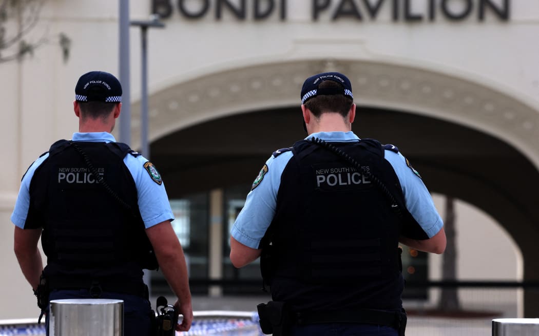Police inspect at the scene of a shooting at Bondi Beach in Sydney on December 15, 2025. Towels, bags and baby strollers littered Sydney's Bondi Beach -- the harrowing aftermath of the country's worst mass shooting in years. Eleven people were killed and many more rushed to hospital in what Australian police are now calling a "terrorist" attack targeting the city's Jewish community during a celebration of Hanukkah. (Photo by DAVID GRAY / AFP)