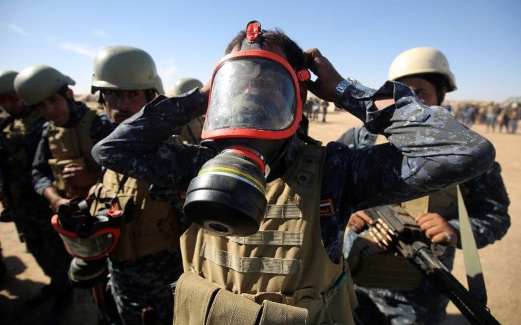 An Iraqi policeman tries on a gasmask at the Qayyarah military base, about 60 kilometres (35 miles) south of Mosul, on October 16, 2016, as they prepare for an offensive to retake Mosul, the last IS-held city in the country,