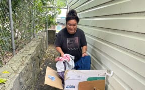 Volunteer Manu with a box full of clothing left at the doorstop of Vinnies afterhours