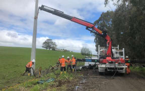 The team at working installing a new power pole in Ermedale, rural Southland.
