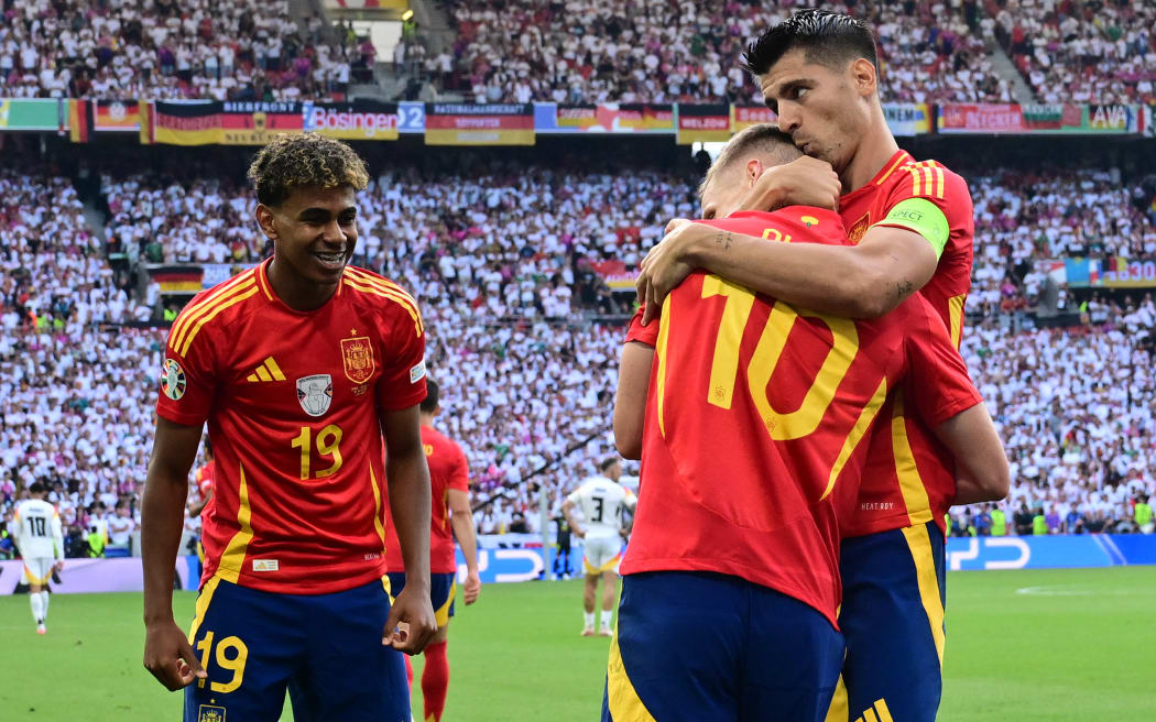 Spain's forward #10 Daniel Olmo celebrates with teammates after scoring his team's first goal during the UEFA Euro 2024 quarter-final football match between Spain and Germany.