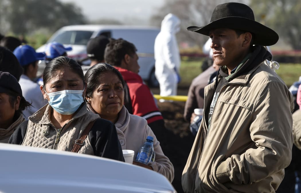 Relatives of victims wait at the scene of a massive blaze trigerred by a leaky pipeline in Tlahuelilpan.