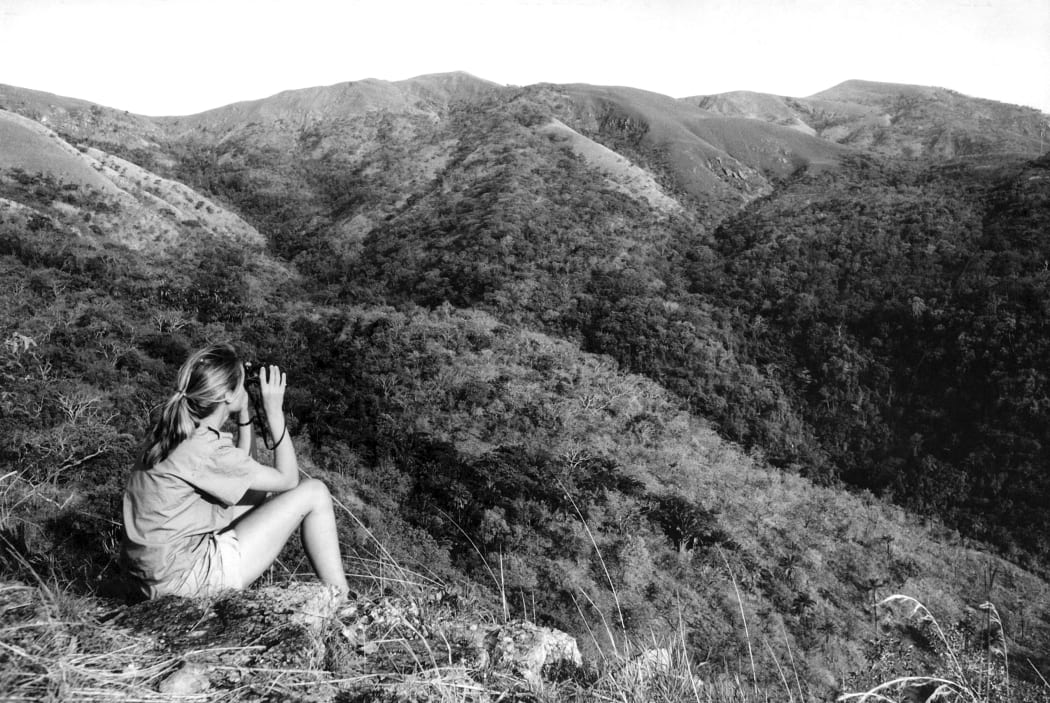 Jane Goodall looking through binoculars.