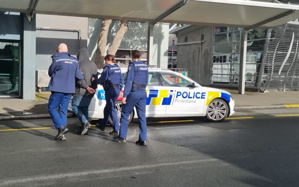 Police officers arrest a man outside New Plymouth's Puke Ariki and bus hub after being reported for waving nunchucks around.