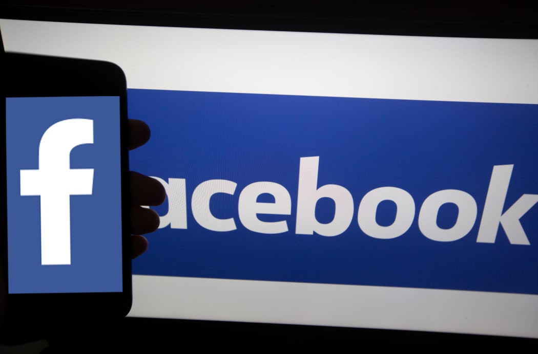The logo of Facebook is seen on a smartphone.