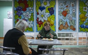 Elderly Ukrainians eat a meal at the old orphanage, which is now used as a refugee camp, in Kryvyi Rig, south of Ukraine, on October 25, 2022, amid the Russian invasion of Ukraine. (Photo by BULENT KILIC / AFP)