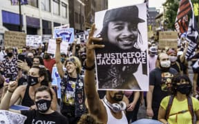 Protesters march near the Minneapolis 1st Police precinct during a demonstration against police brutality and racism on August 24, 2020.