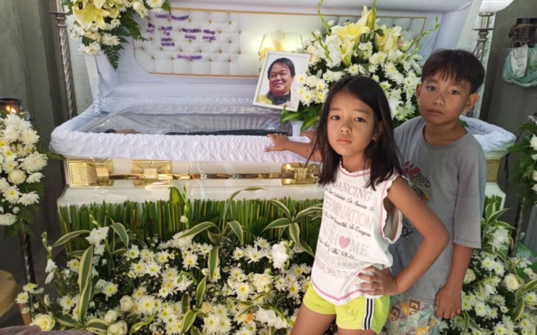 Hermone and Durt Lozano with their father's coffin.