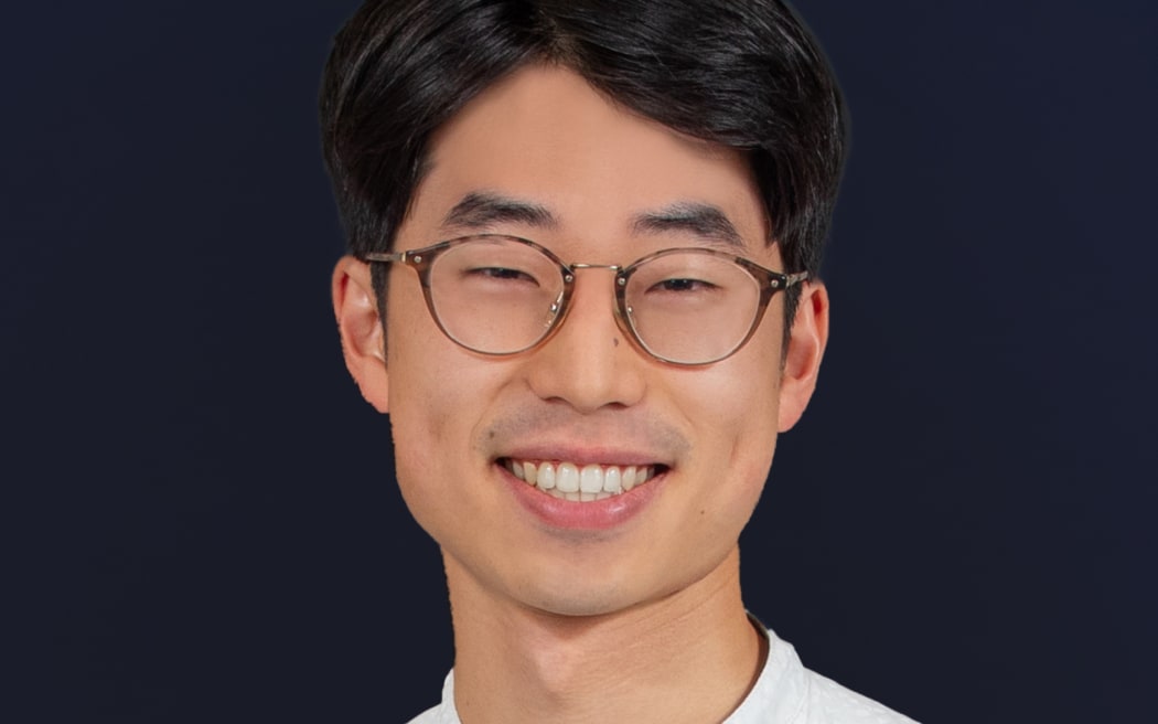 Miru Shimaoka smiling in front of dark blue background