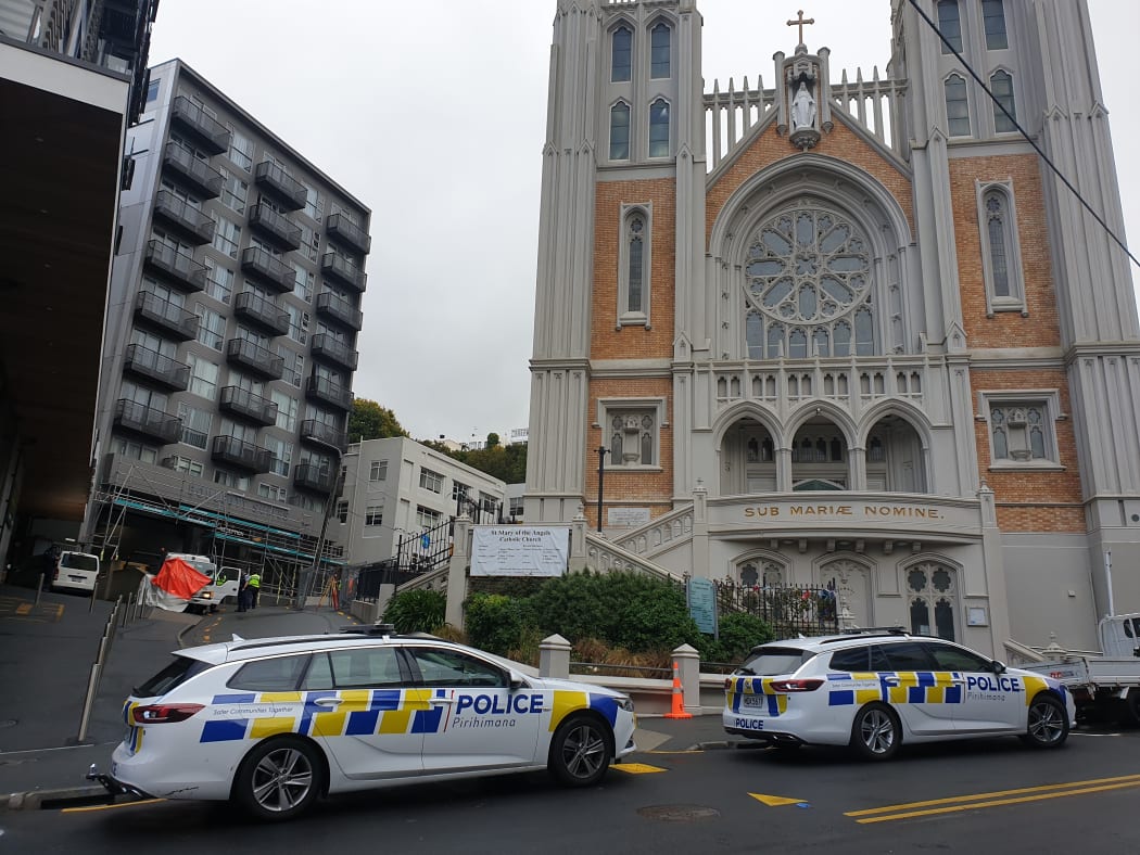 Police examine the small truck, in the alley between apartments and St Mary of the Angels church in central Wellington.