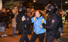 Police officers detain a woman in Moscow on 21 September 2022, following calls to protest against partial mobilisation announced by President Vladimir Putin.